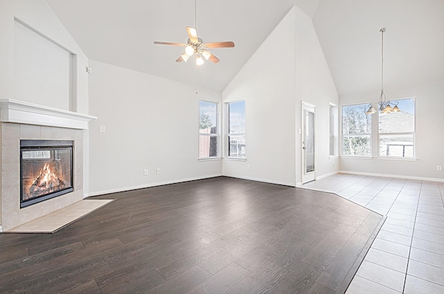 unfurnished living room featuring a wealth of natural light, a tile fireplace, and wood finished floors