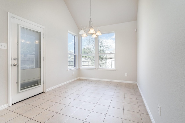 empty room featuring lofted ceiling, light tile patterned floors, baseboards, and a notable chandelier