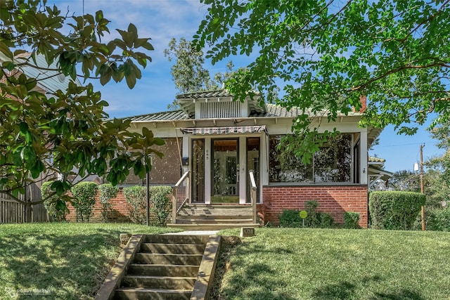 view of front of home featuring brick siding and a front yard