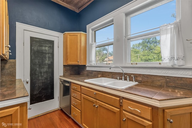 kitchen with dark wood-style floors, brown cabinets, a sink, and dishwasher