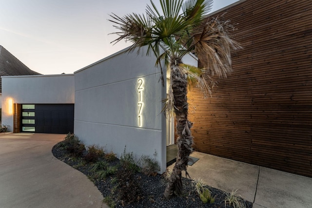 view of side of home featuring driveway and stucco siding