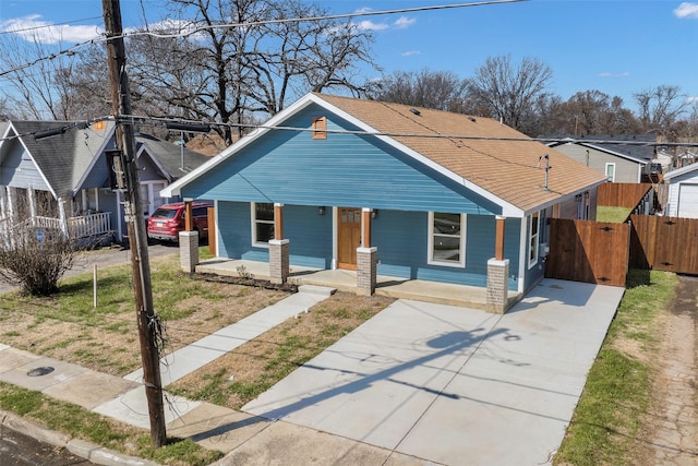 bungalow-style home featuring a residential view, covered porch, and fence