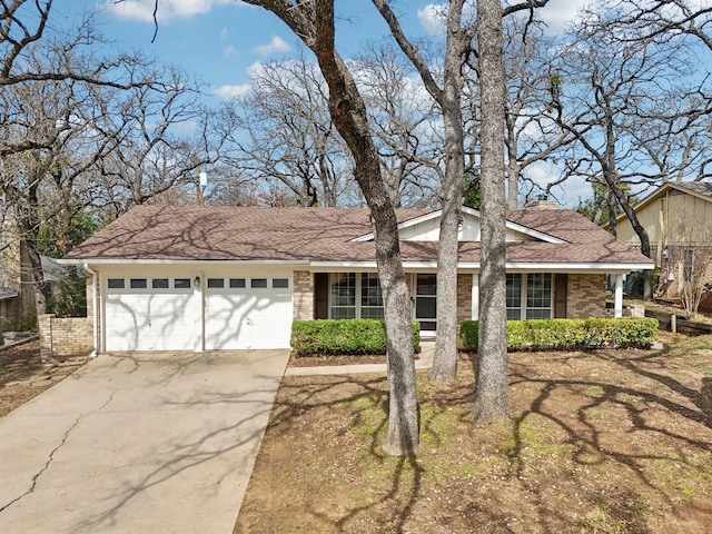 ranch-style house featuring a garage, concrete driveway, and brick siding