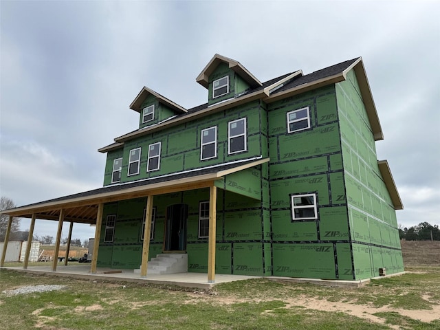 back of property featuring covered porch and a carport