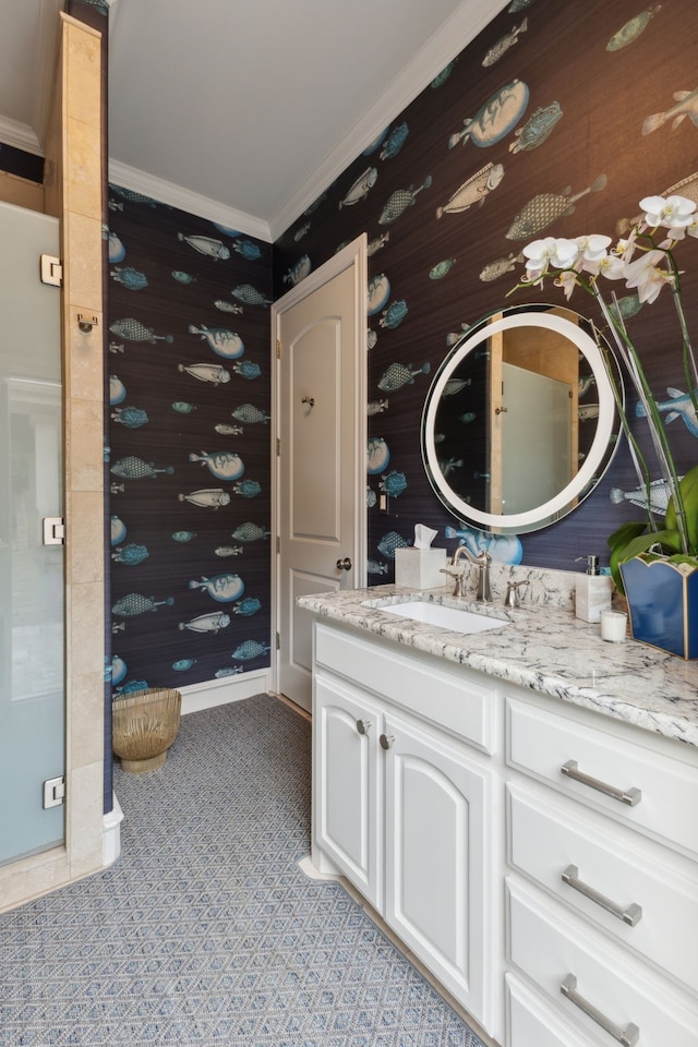 bathroom featuring crown molding, vanity, baseboards, and wallpapered walls