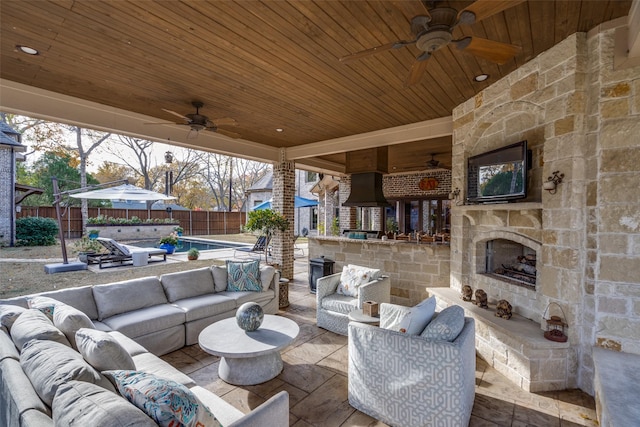 view of patio with a ceiling fan, a fenced backyard, and an outdoor living space with a fireplace