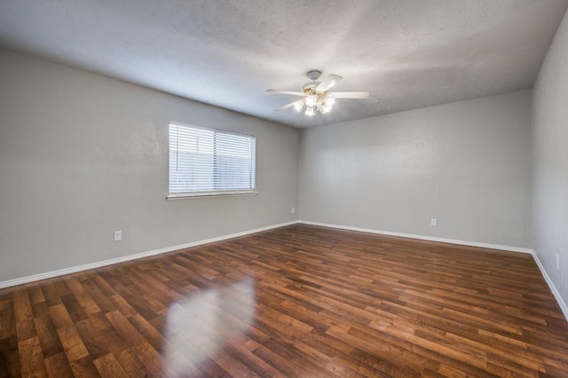 empty room with dark wood-type flooring, ceiling fan, a textured ceiling, and baseboards