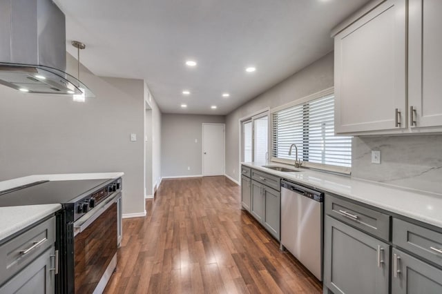 kitchen with island range hood, a sink, hanging light fixtures, appliances with stainless steel finishes, and light countertops