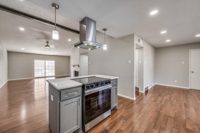 kitchen with electric range, island range hood, open floor plan, hanging light fixtures, and light countertops