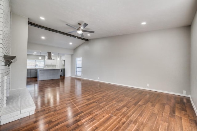 unfurnished living room with baseboards, dark wood finished floors, a ceiling fan, vaulted ceiling with beams, and a brick fireplace