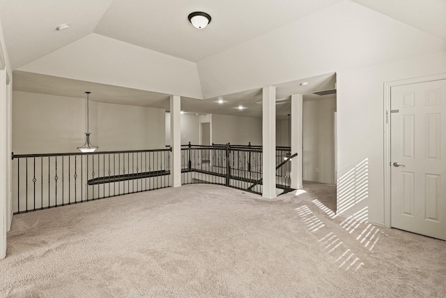 spare room featuring light carpet, visible vents, and vaulted ceiling