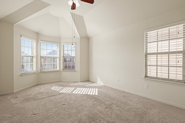 empty room featuring carpet floors, lofted ceiling, ceiling fan, and baseboards