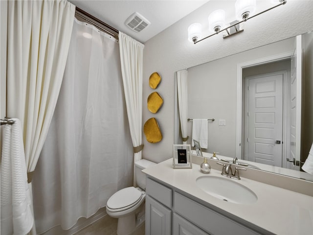 full bathroom with toilet, vanity, and visible vents