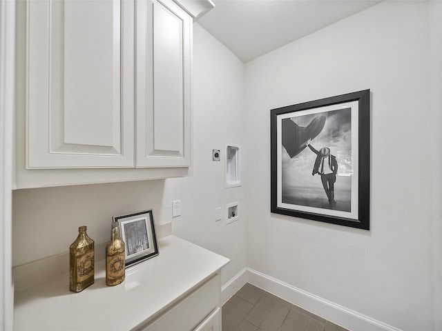 washroom featuring washer hookup, cabinet space, electric dryer hookup, and baseboards