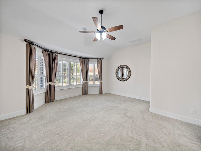 unfurnished room with lofted ceiling, light colored carpet, visible vents, a ceiling fan, and baseboards