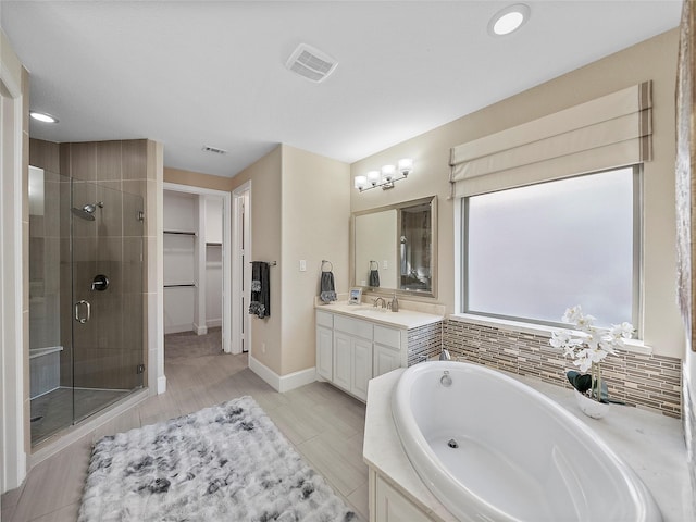 full bath with visible vents, vanity, a spacious closet, a shower stall, and a bath