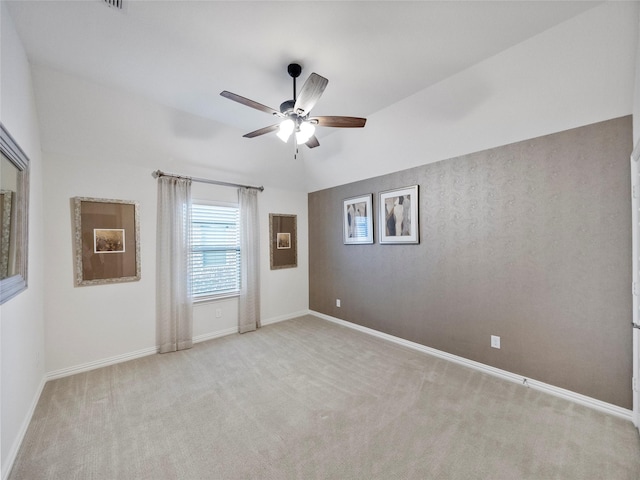 empty room with light colored carpet, ceiling fan, and baseboards