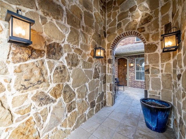 doorway to property featuring stone siding and brick siding