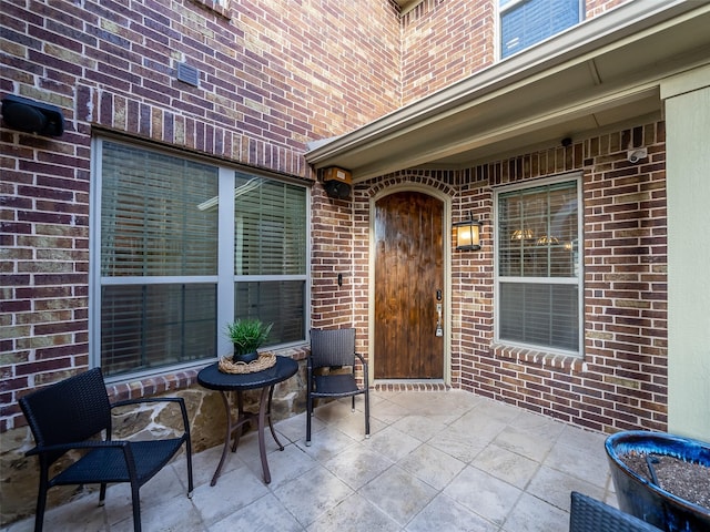 doorway to property with a patio and brick siding