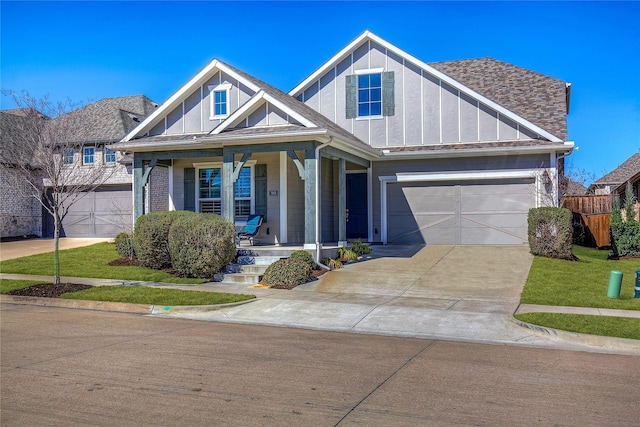 craftsman house featuring a garage, roof with shingles, covered porch, fence, and board and batten siding