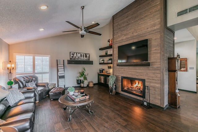 living area with dark wood finished floors, lofted ceiling, visible vents, a large fireplace, and a textured ceiling