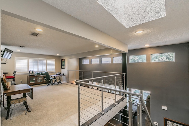 corridor with a textured ceiling, recessed lighting, carpet flooring, an upstairs landing, and baseboards