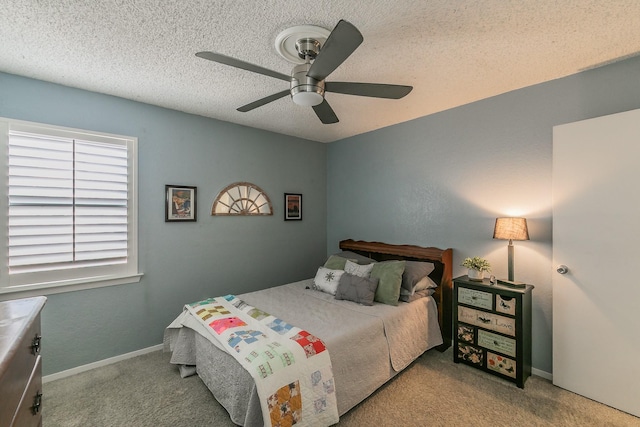 bedroom featuring a ceiling fan, baseboards, a textured ceiling, and light colored carpet