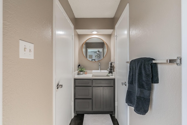 bathroom with a textured wall and vanity