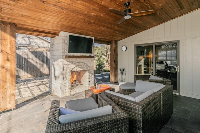 view of patio / terrace with a ceiling fan, an outdoor stone fireplace, and fence