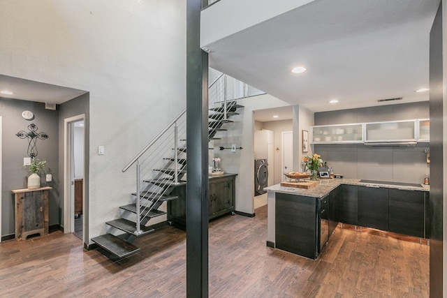 interior space with recessed lighting, dark wood-style flooring, a towering ceiling, visible vents, and washer / clothes dryer