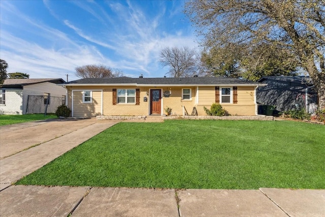 ranch-style home with brick siding, fence, and a front lawn