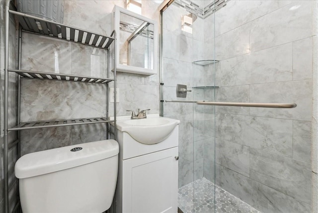 full bathroom featuring tile walls, a shower stall, toilet, and vanity