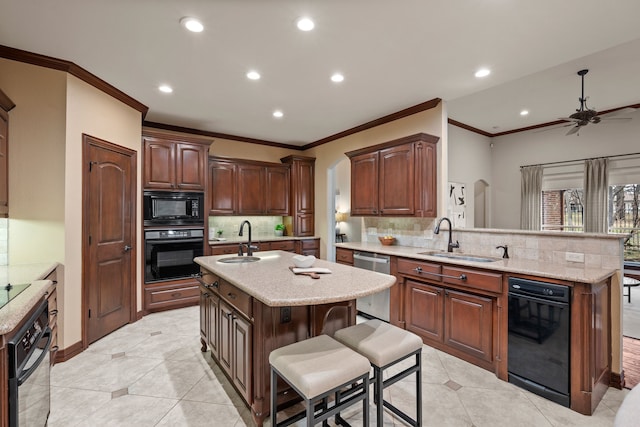 kitchen featuring a breakfast bar area, a sink, a peninsula, and black appliances