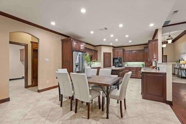 dining room featuring arched walkways, ornamental molding, visible vents, and recessed lighting