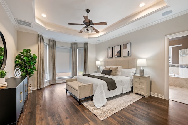 bedroom featuring visible vents, a raised ceiling, dark wood finished floors, and ensuite bathroom