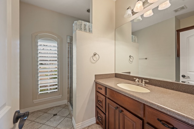 full bath with visible vents, an enclosed shower, vanity, baseboards, and tile patterned floors