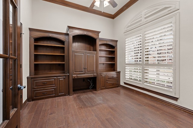 unfurnished office with plenty of natural light, built in study area, dark wood-style floors, ceiling fan, and crown molding