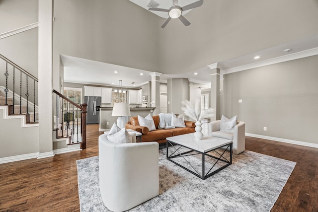 living room with ornate columns, stairs, baseboards, and wood finished floors