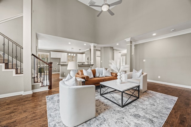 living room with dark wood-style floors, decorative columns, stairs, and baseboards