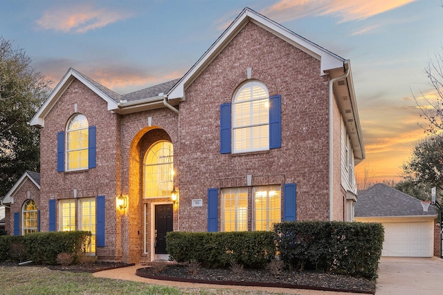 traditional home with a garage and brick siding