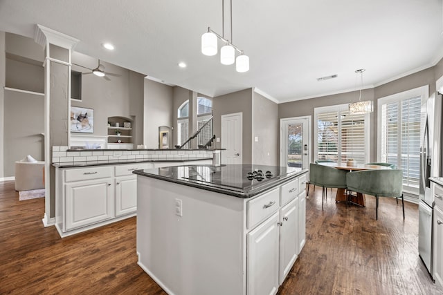 kitchen with dark countertops, white cabinetry, and pendant lighting