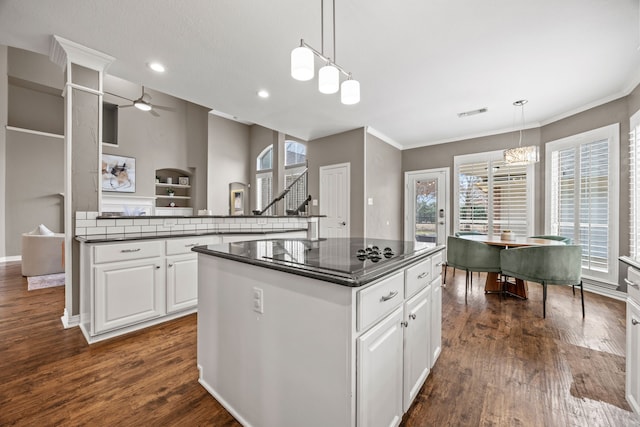 kitchen featuring dark countertops, white cabinetry, and hanging light fixtures