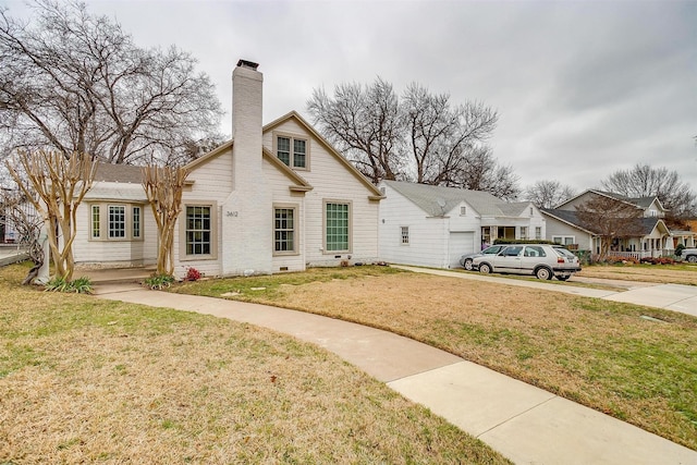 view of front facade with an attached garage, crawl space, a chimney, and a front yard