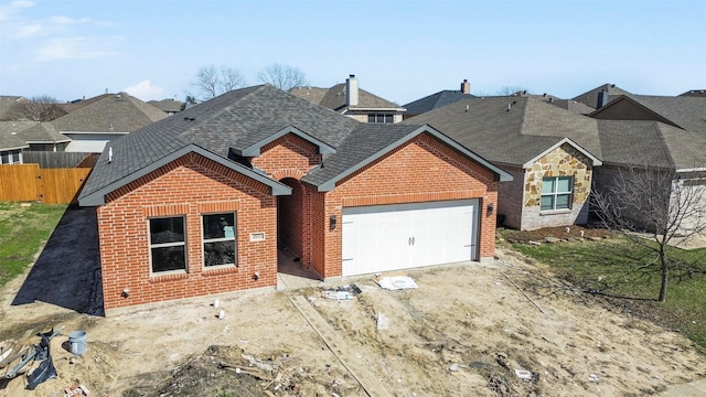 view of front of home with a garage, a shingled roof, brick siding, fence, and stone siding