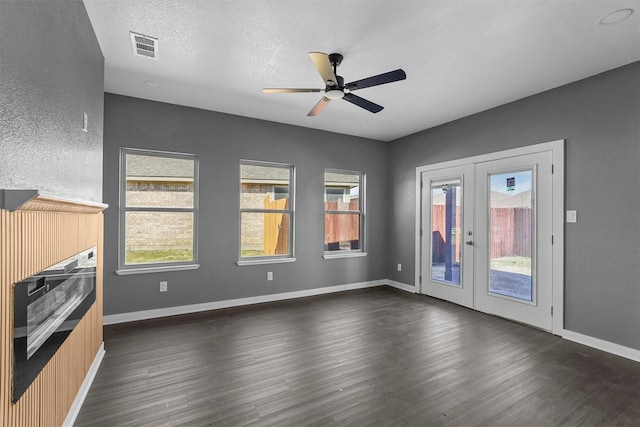 interior space with french doors, dark wood-style flooring, visible vents, and baseboards