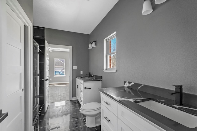 bathroom with a wealth of natural light, two vanities, and a sink