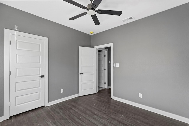 unfurnished bedroom featuring dark wood-style flooring, visible vents, ceiling fan, and baseboards