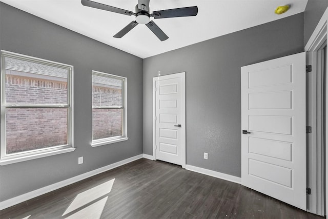 unfurnished bedroom featuring a closet, dark wood-style flooring, baseboards, and a ceiling fan