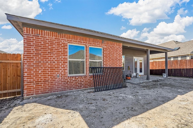 back of house with fence, a patio, and brick siding