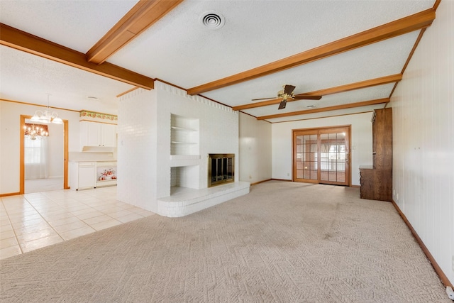 unfurnished living room with visible vents, light colored carpet, beamed ceiling, a textured ceiling, and a fireplace